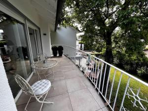 a balcony with a table and chairs and a tree at KLIMATISIERTE schöne 110 qm große moderne und helle Wohnung in Heilbronn