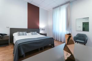 um quarto com uma cama e uma cadeira azul em Villa Albina em Nápoles