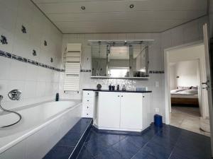 a bathroom with a tub and a sink and a bath tub at KLIMATISIERTE schöne 110 qm große moderne und helle Wohnung in Heilbronn +33 photos