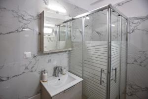 a bathroom with a sink and a glass shower at MG apartments in Alexandroupoli +20 photos