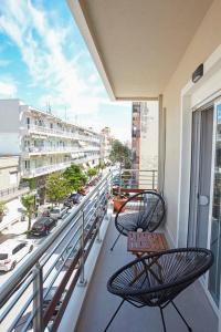 2 stoelen en een tafel op een balkon met uitzicht op de stad bij MG apartments in Alexandroupoli