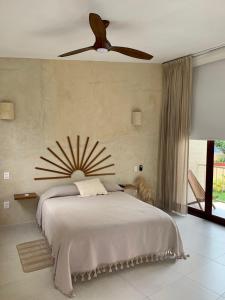 a bedroom with a bed with a ceiling fan at La Bohème Sayulita in Sayulita