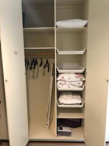 a walk in closet with white shelves at Lovely apartment within walking distance -centre in Pori