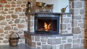 希俄斯Stone Residence Chios的石头壁炉,壁炉内有火