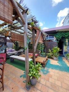 a patio with a wooden pergola at The GREEN Hostel in Pointe-à-Pitre