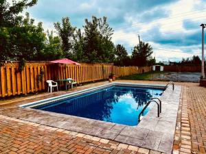 a small swimming pool in a backyard with a fence at Hotel Motel Granby in Granby