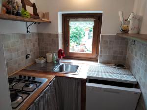 a small kitchen with a sink and a window at Adelaide House by casa Shanty in Calasca Castiglione