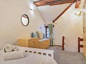 1 dormitorio con cama, tocador y espejo en Agniti Cottage, en Derby