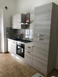 a kitchen with white cabinets and a stove top oven at Home Ciccilla in Reggio Calabria