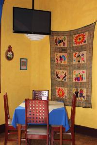 ein Esszimmer mit einem Tisch und einem TV an der Wand in der Unterkunft Hotel Los Arcos in Estelí