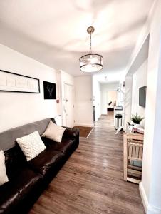 a living room with a leather couch and a hallway at BEST LOCATION Central London 2 Bedrooms Sleeps up to 4 or 5 Middle of all attractions in London