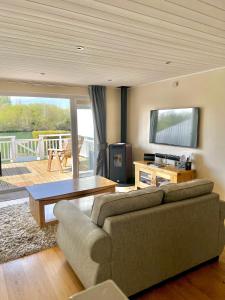 ein Wohnzimmer mit einem Sofa und einem Tisch in der Unterkunft Grange Lodge in South Cerney
