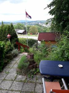 un banco azul en un jardín con bandera en Ferienhaus Sommerland Auszeithütte, en Freyung