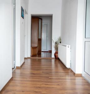 un corridoio vuoto con pavimenti in legno e pareti bianche di Къща за гости Край реките ad Apriltsi
