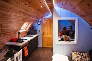 a couple in the kitchen of a tiny house at Fulshaw Mill Holidays in Stewarton