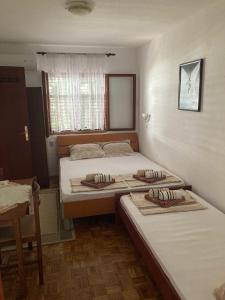 a bedroom with two beds and a window at Apartments Aleksic in Sutomore