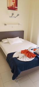 białe łóżko z niebieskim kocem w obiekcie Hotel Tassos-Despina w mieście Pefkochori