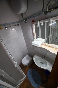 y baño con lavabo, aseo y espejo. en Il Quattro en Alghero