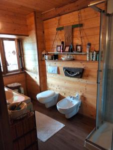 a bathroom with a toilet and a sink in a cabin at Adelaide House by casa Shanty in Calasca Castiglione