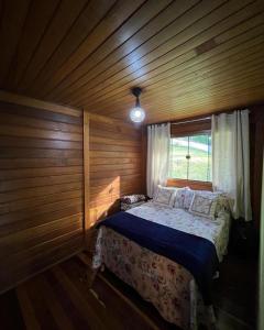 a bedroom with a bed in a wooden room at Recanto Della Mata in Venda Nova do Imigrante