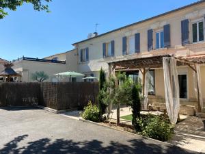 una casa con una recinzione e alberi di fronte ad essa di L'Escale des Alpilles a Rognonas