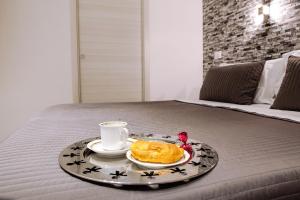 a tray with a plate of food and a cup on a bed at Venere Rooms in Termoli