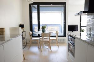 cocina con mesa, sillas y ventana en 2ndhomes Mikonkatu Apartment 6 en Helsinki