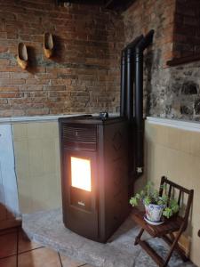 a wood stove in a room with a chair at Casa La Cobaraza Vivienda Vacacional in Llanes