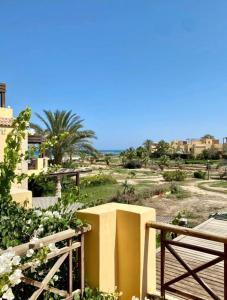 艾因蘇赫納的住宿－A sea view spacious cheering 5 bedroom villa Ain Sokhna "Ain Bay" فيلا كاملة للإيجار قرية العين باي，一座黄色的建筑,有栅栏,还有一片树木林立的田野