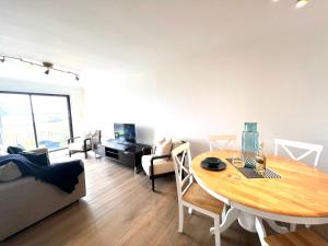 a living room with a dining room table and a couch at Bellevue Apartment in Largs