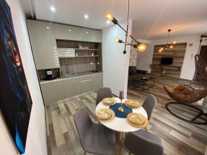 a dining room with a table and some chairs at Apartament Ella T8 in Mamaia Sat/Năvodari