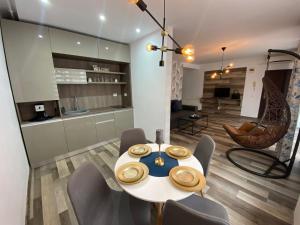 a kitchen and dining room with a table and chairs at Apartament Ella T8 in Mamaia Sat/Năvodari