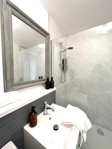 a bathroom with a sink and a mirror and a shower at Bellevue Apartment in Largs +124 photos
