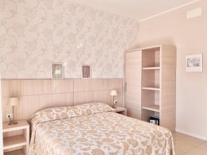 a bedroom with a bed with a floral wallpaper at Santa Barbara hotel & apartments in Bellaria-Igea Marina +154 photos