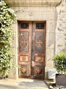 uma grande porta de madeira no lado de um edifício em L'oiseau Bleu FLAMANT em Roubia