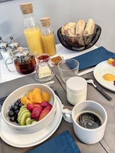 uma mesa com uma tigela de fruta e um prato de pão em L'oiseau Bleu FLAMANT em Roubia