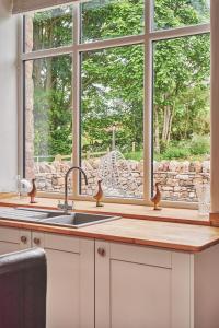 cocina con fregadero y ventana en Plum Cottage, en Appleby