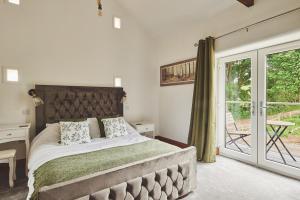 a bedroom with a bed and a sliding glass door at Plum Cottage in Appleby