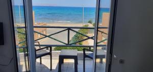 a room with a view of the ocean from a balcony at Stella Apartments in Kokkíni Khánion