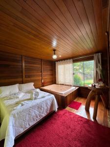 a bedroom with a bed and a large window at Recanto Della Mata in Venda Nova do Imigrante