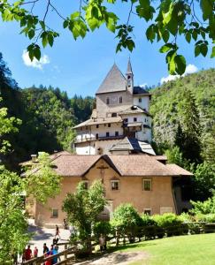 a castle on top of a hill with people standing in front at Agritur LA FENICE in Brez