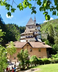 zamek na szczycie wzgórza, przed którym stoją ludzie w obiekcie Agritur La Fenice w mieście Brez