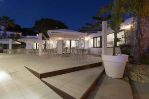 a patio area with tables, chairs and umbrellas at Apartamentos Honorio - Pool and Garden in Vilamoura