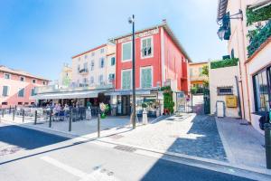 a city street with tables and buildings on a sunny day at CAP FERRAT VIEW II AP4296 by Riviera Holiday Homes in Saint-Jean-Cap-Ferrat