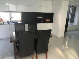 a kitchen with black chairs and a wooden table at Apartmány Dimitra 2 in Štúrovo