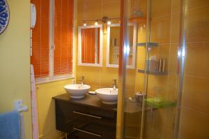 a bathroom with two sinks and a glass shower at Appartement LA VIE EN ROSE in Périgueux
