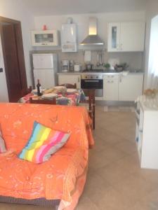 sala de estar con sofá naranja y cocina en Villa Giovanna Apt. B, en Sestri Levante