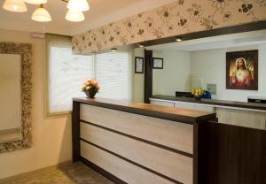 a salon with a reception counter with a mirror at Pousada Florenza in Bento Gonçalves