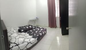 a bedroom with a black and white bed in a room at JANNAH HOMESTAY in Putrajaya