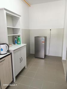 a kitchen with a stainless steel refrigerator in a room at JANNAH HOMESTAY in Putrajaya